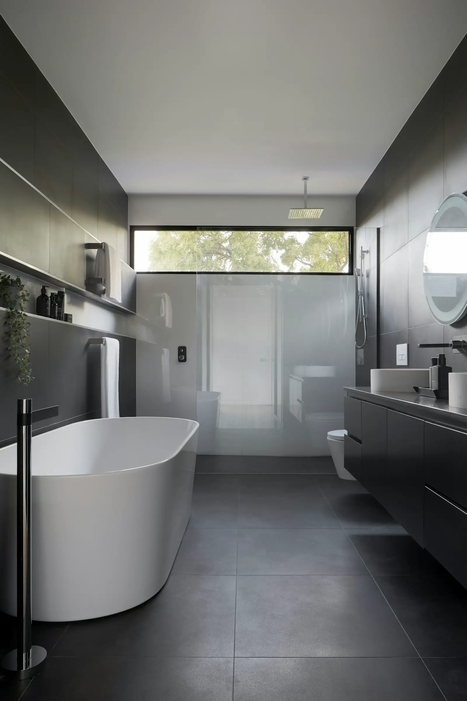 A bathroom with a tub, a glass shower, and a dark vanity. Shown on the homepage for Reno, NV.